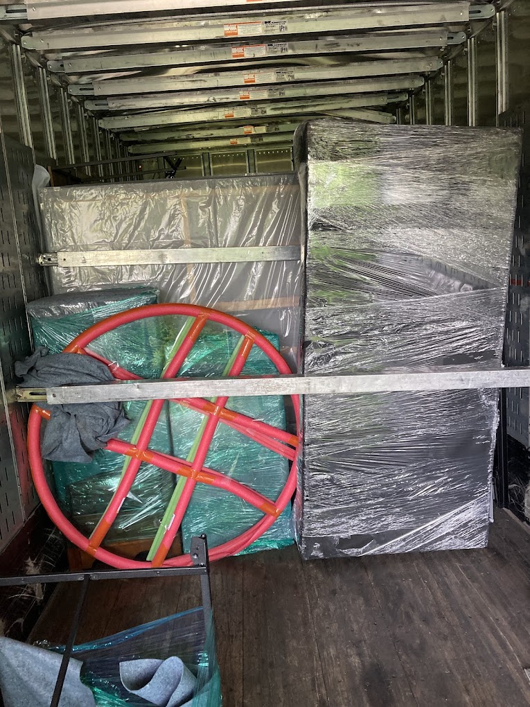 Wrapped furniture and items carefully loaded in moving truck
