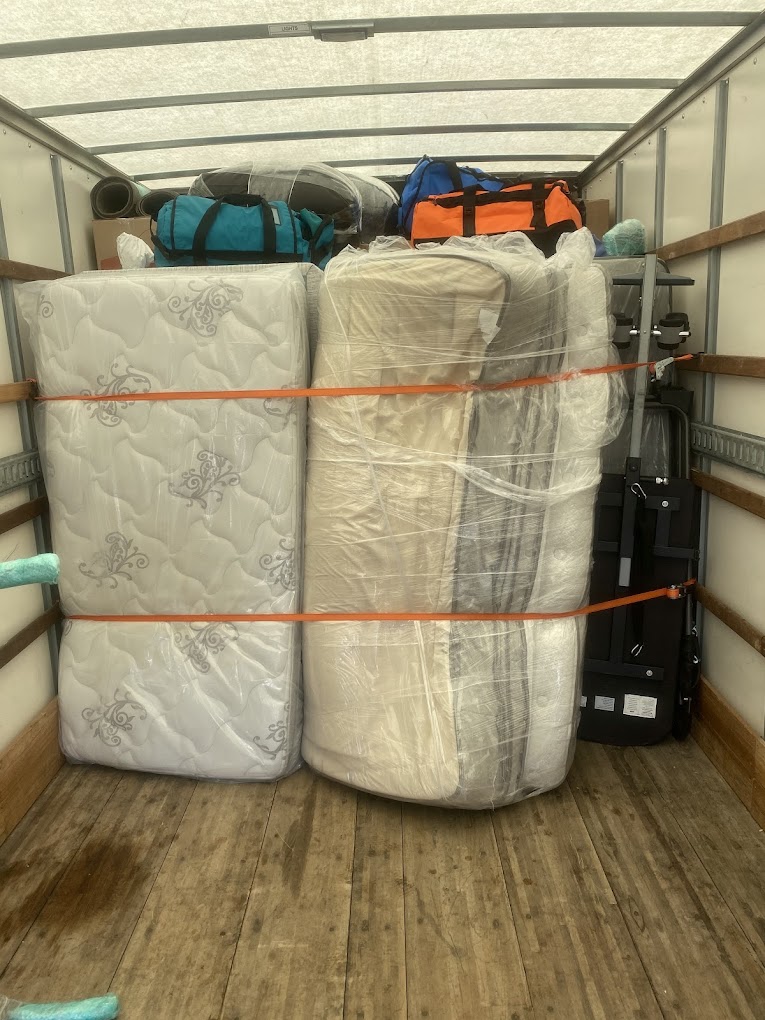 Mattresses and belongings strapped inside a Movers & More moving truck